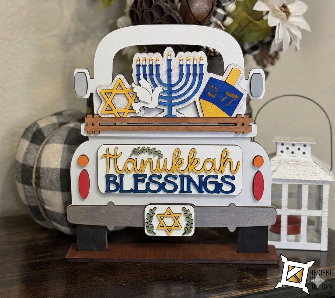 A wooden farmhouse truck display with an interchangeable insert that has a blue menorah, a gold Star of David, and a dreidel, with a tailgate that says "Hanukkah Blessings."